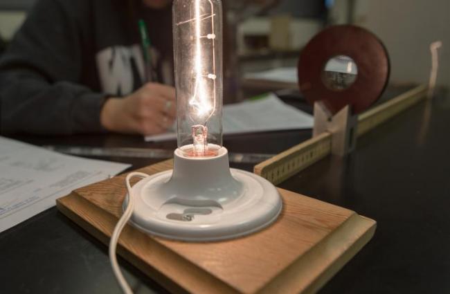 Image of lamp with student studying in background